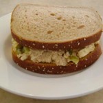 Chicken salad sandwich placed on a white plate.