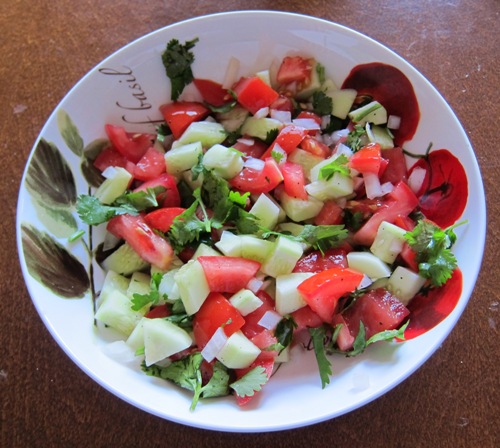 salad with chopped tomatoes, cucumbers, onion slices and cilantro