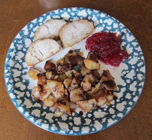 sliced turkey breast with cranberry sauce and fried potatoes