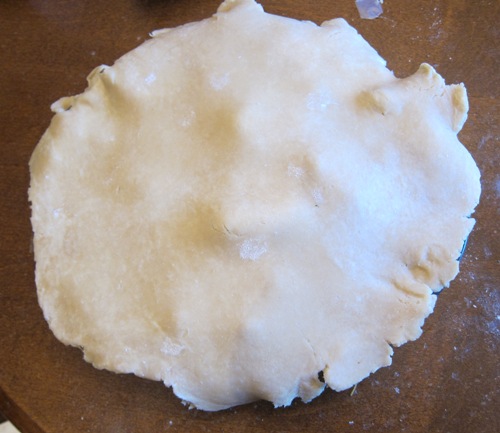 adding the top crust to the apple pie