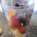 banana, blueberry and peach slices in a blender for a smoothie