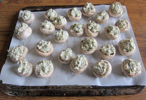 stuffed mushrooms with filling on a baking sheet