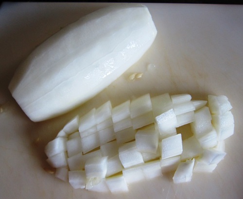 chopping white cucumber on a cutting board