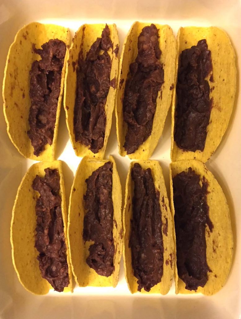 refried beans in the taco shells