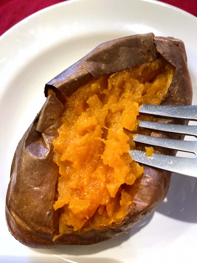 eating a sweet potato with a fork