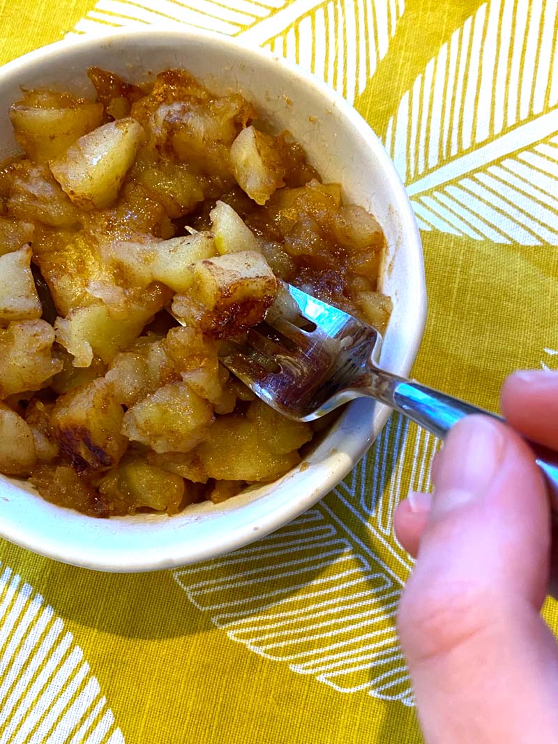 Eating the fried apples with a fork