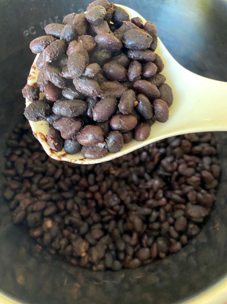 scooping out some tender black beams from the instant pot