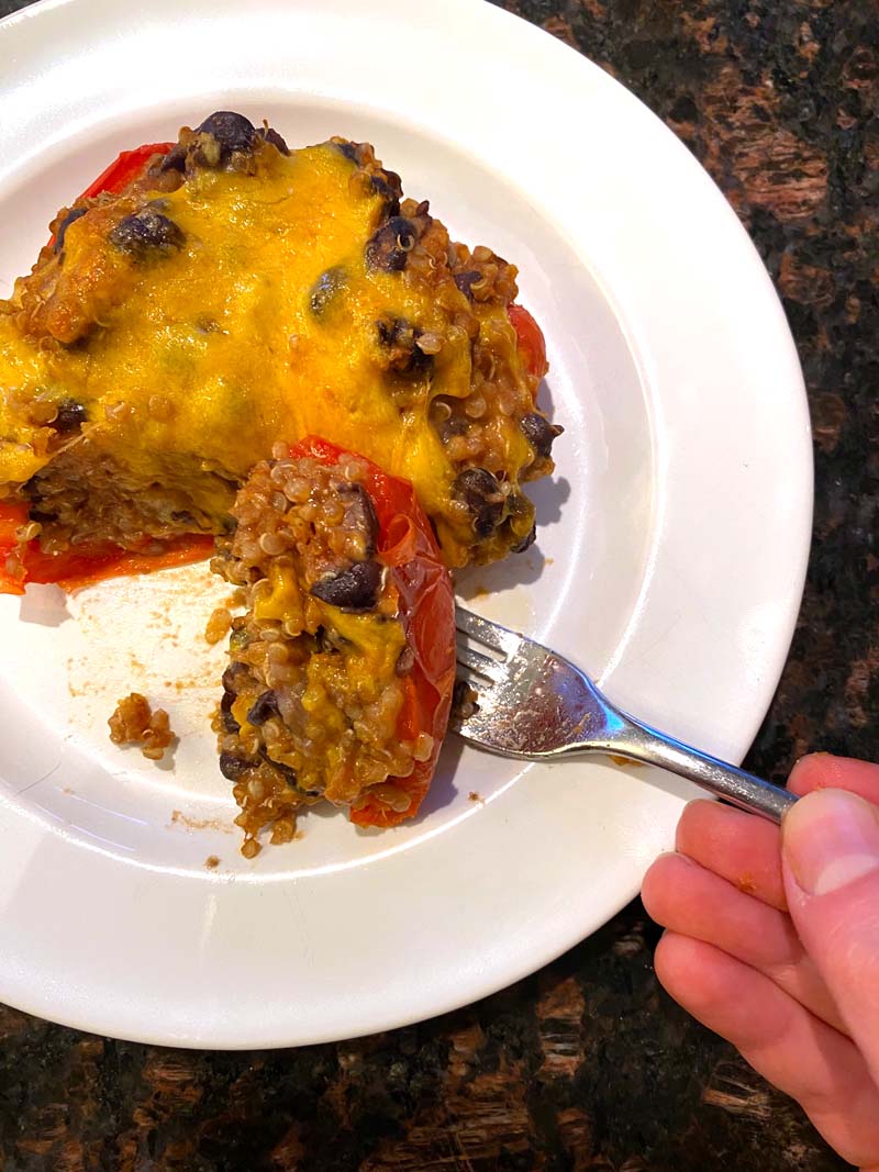 A vegetarian stuffed pepper being eaten with a fork