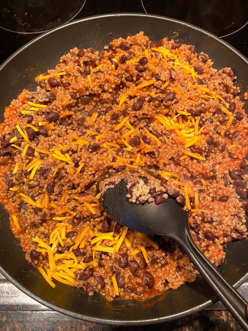 Cheese being stirred into the filling in the skillet