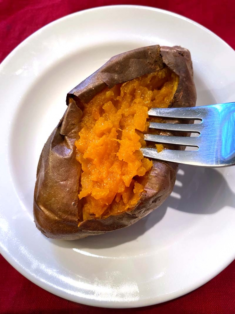 eating baked sweet potato with fork