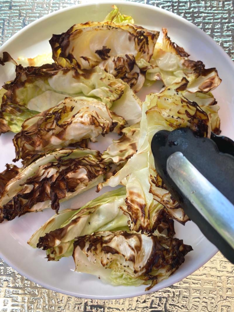 Serving air fried cabbage wedges with tongs