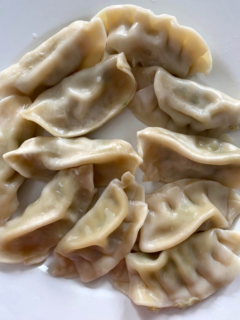 a plate of cooked chinese dumplings