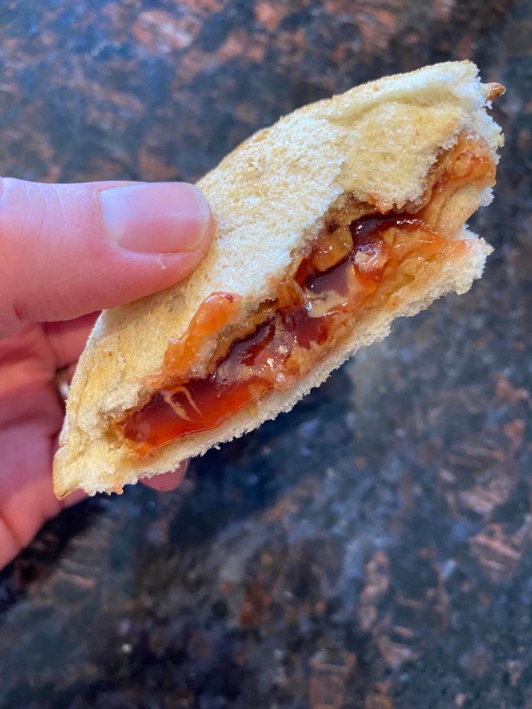 taking a bite of peanut butter and jelly uncrustable