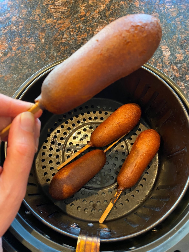 eating a sausage pancake corn from air fryer 