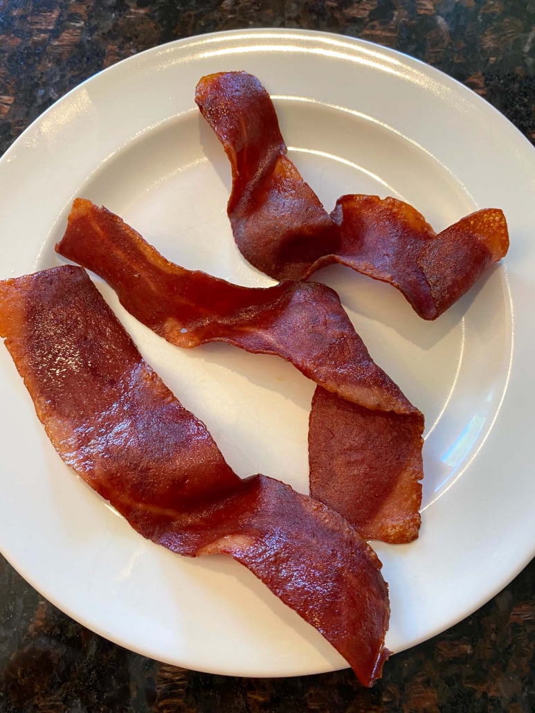 three pieces of cooked turkey bacon on a plate