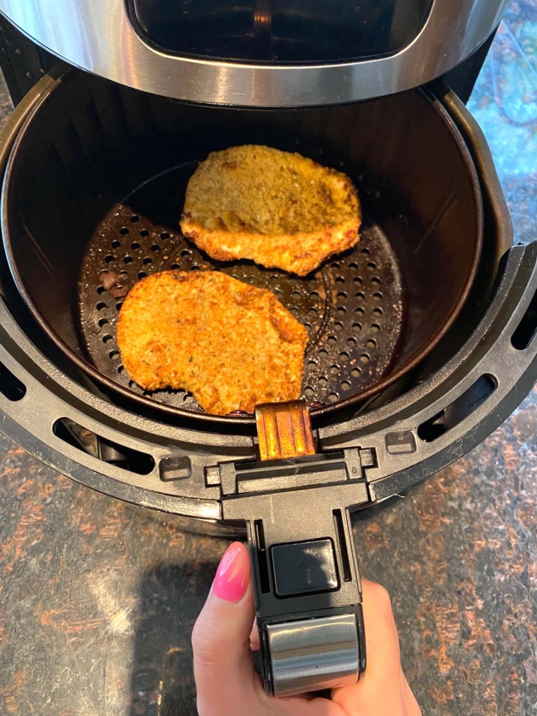 two chicken cutlets going in the air fryer