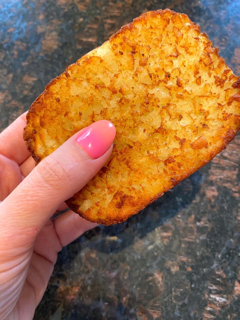 hand holding air fried hash brown patty