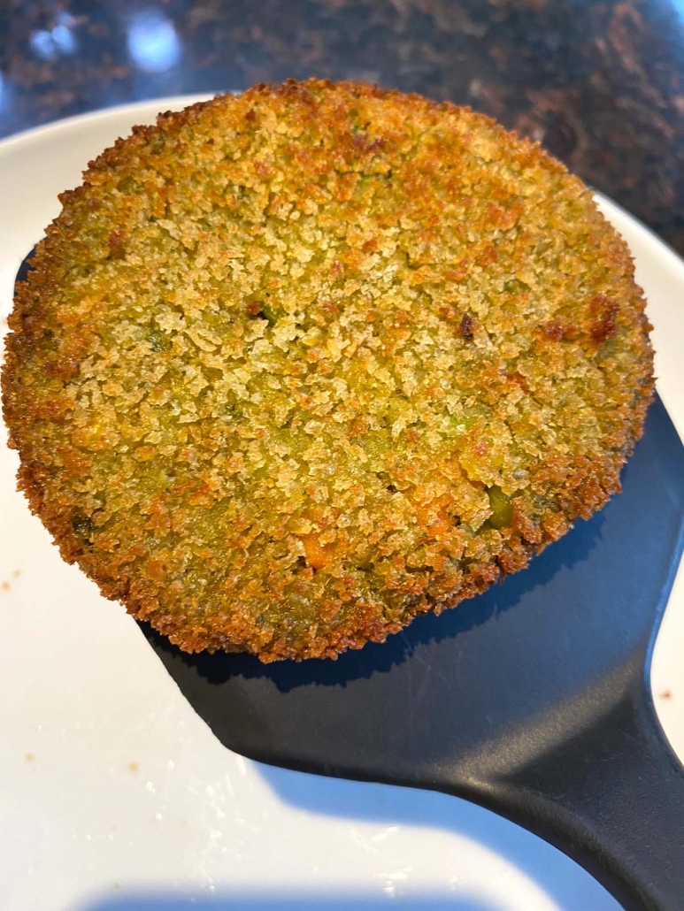 veggie burger on a spatula over a plate