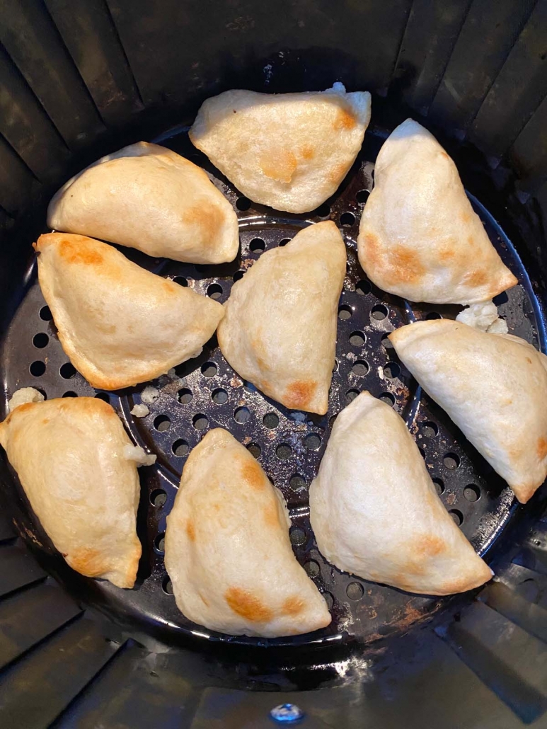 close up of pierogies in air fryer basket