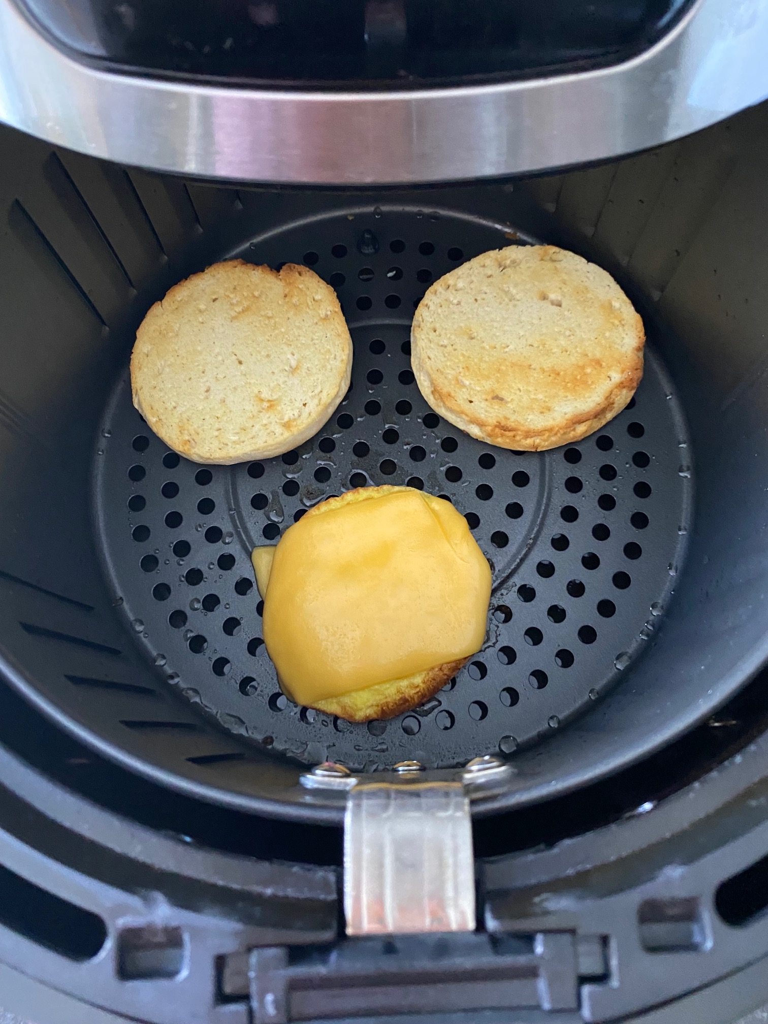 Breakfast sandwich layers in an air fryer.