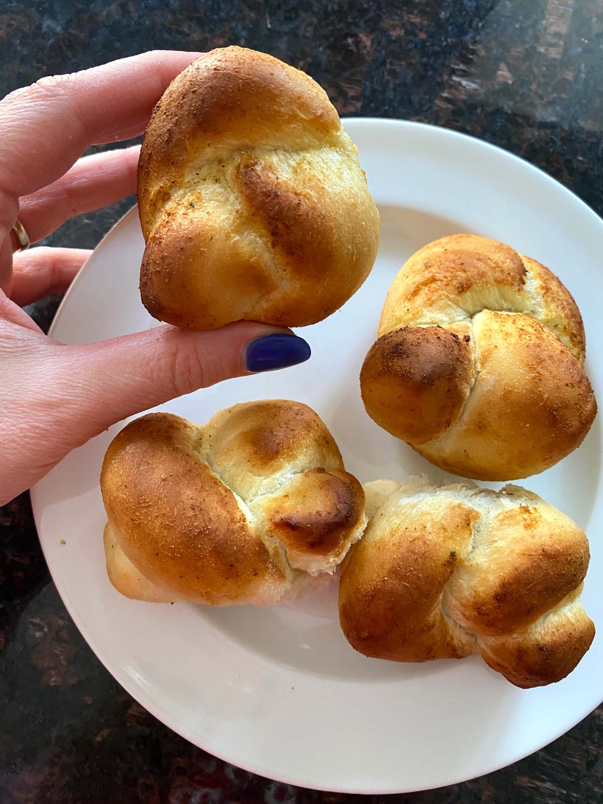 Baked garlic knots on a white plate. 