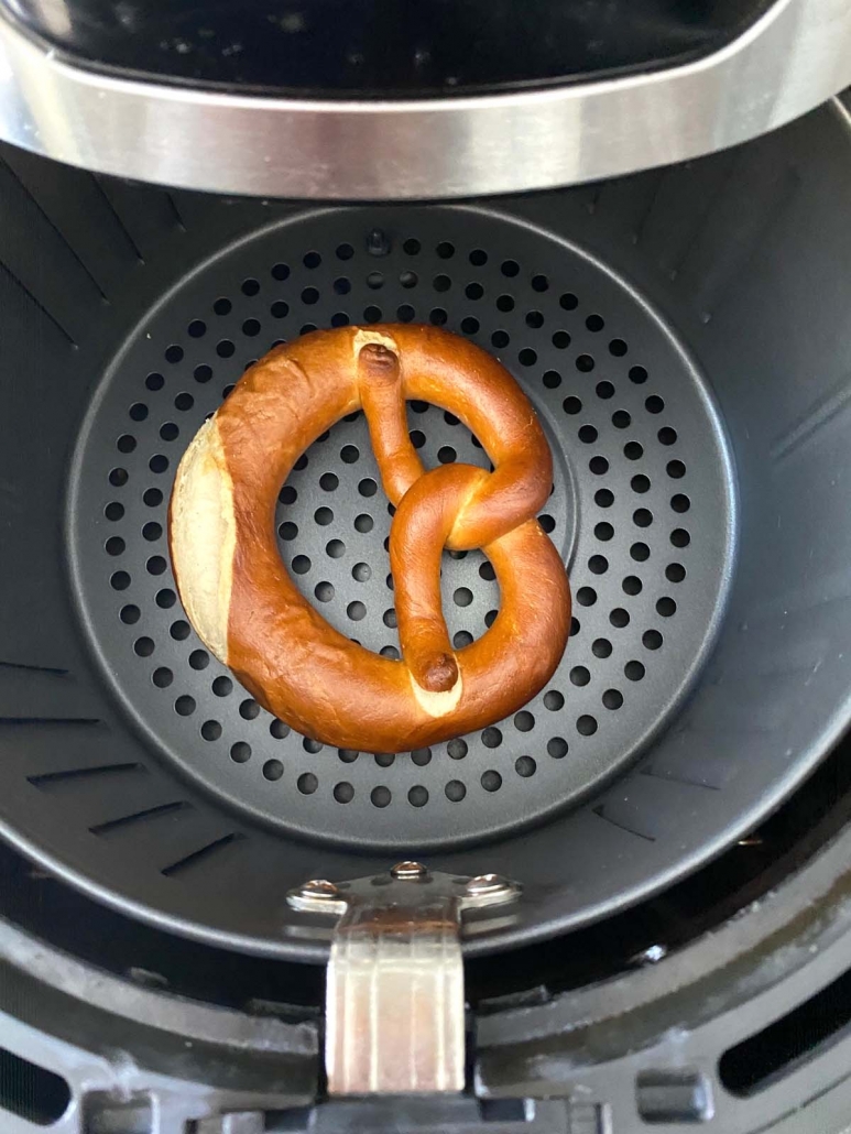 overhead shot of soft pretzel cooking in the air fryer basket