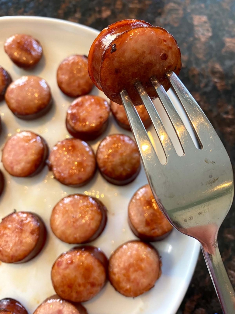 fork holding piece of cooked kielbasa