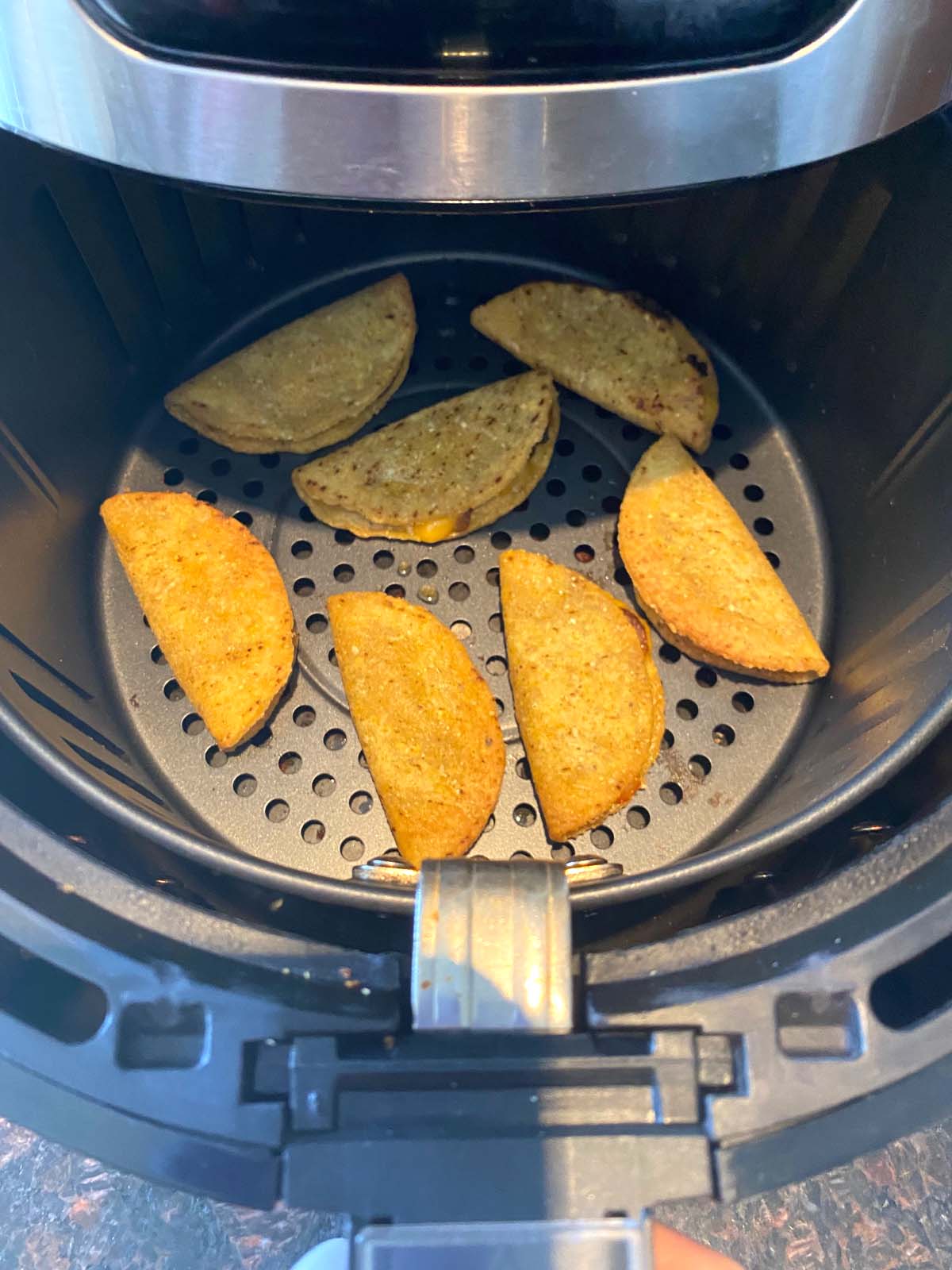 Beef and cheese corn tacos in convection oven basket.