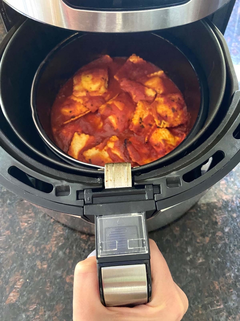 air fryer opened to show Cheese Ravioli With Marinara Sauce