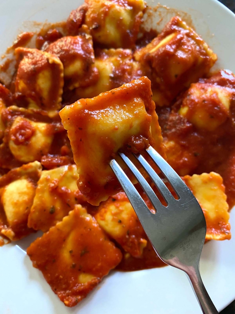 fork holding Cheese Ravioli With Marinara Sauce