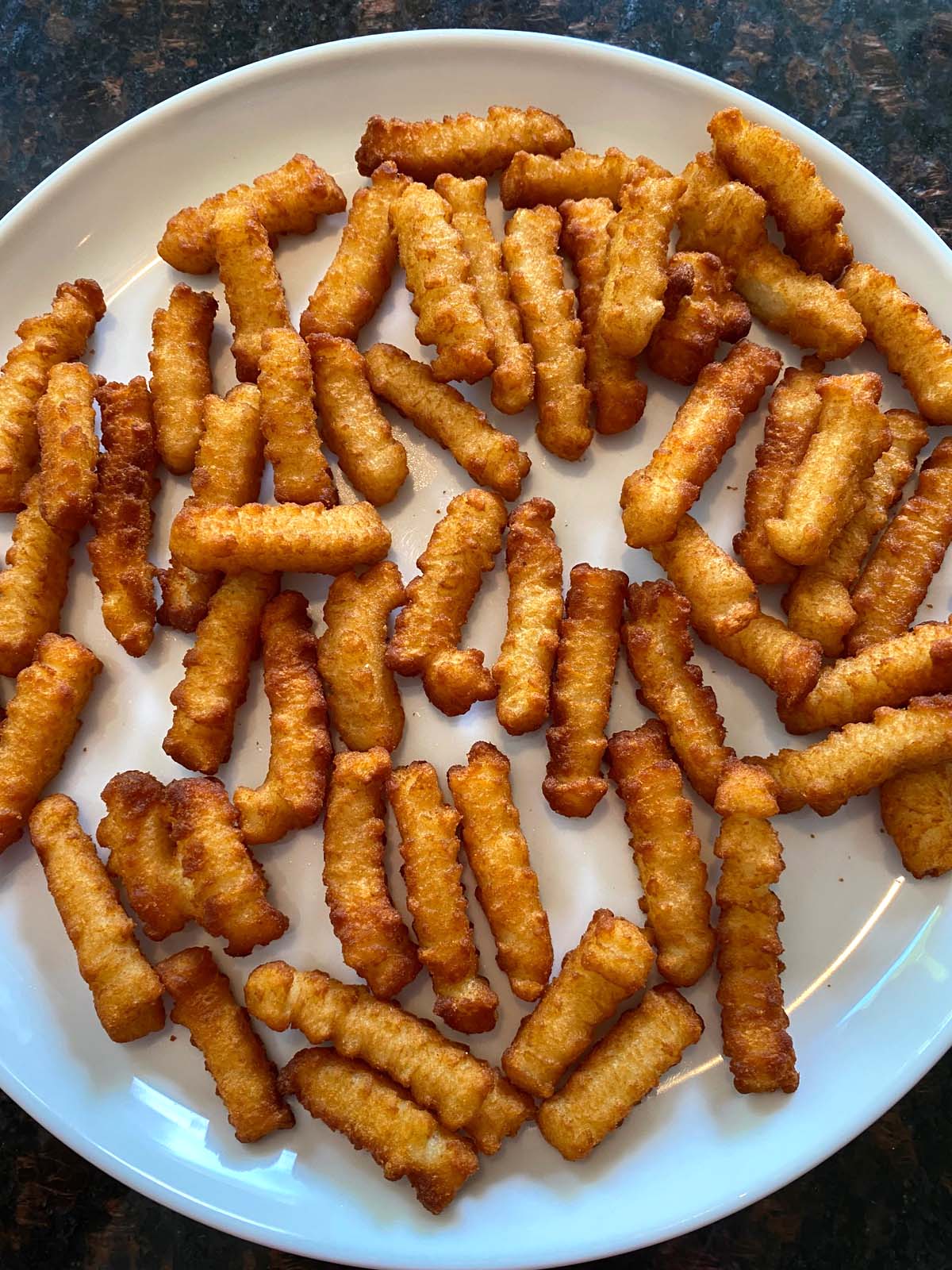 bags of Ore Ida brand frozen french fries in the freezer section