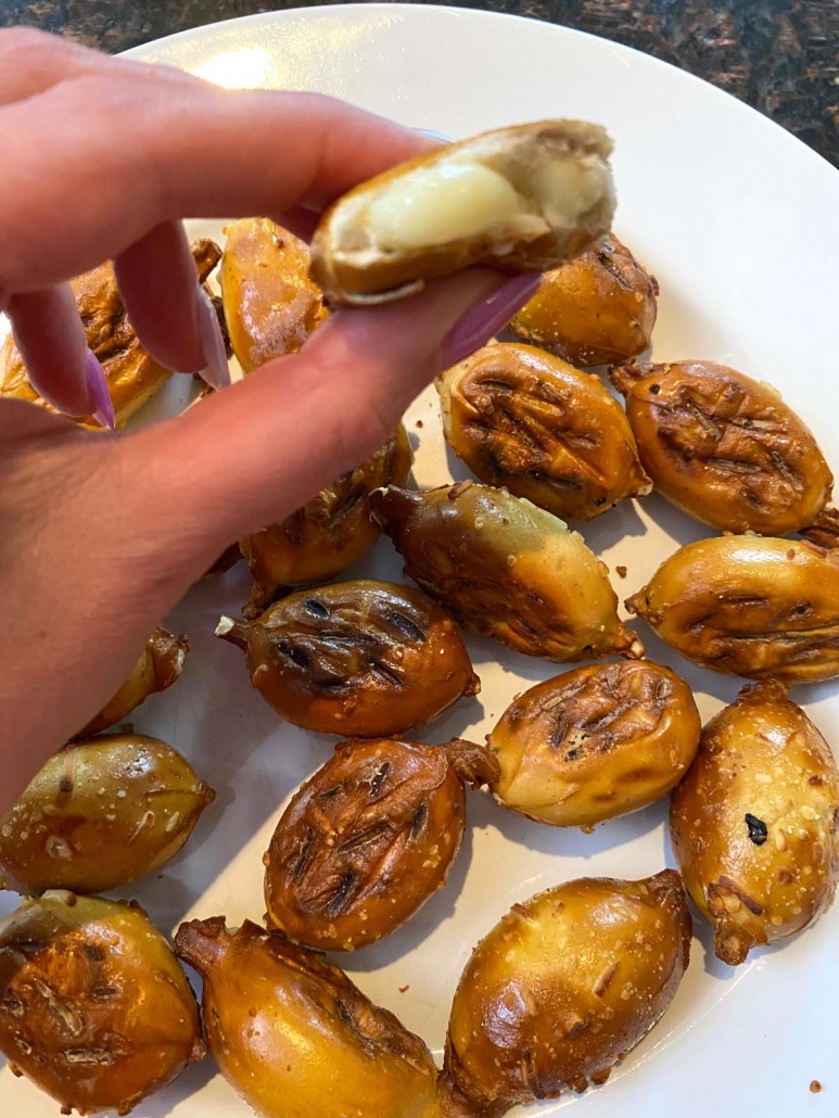 hnad holding pretzel bite showing melted cheese inside