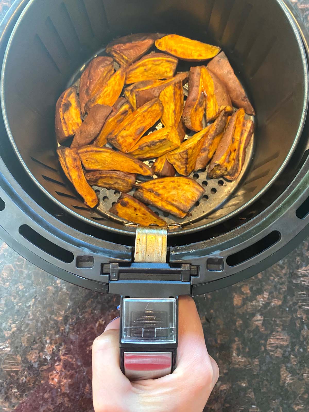 Cooked sweet potato wedges in an air fryer.