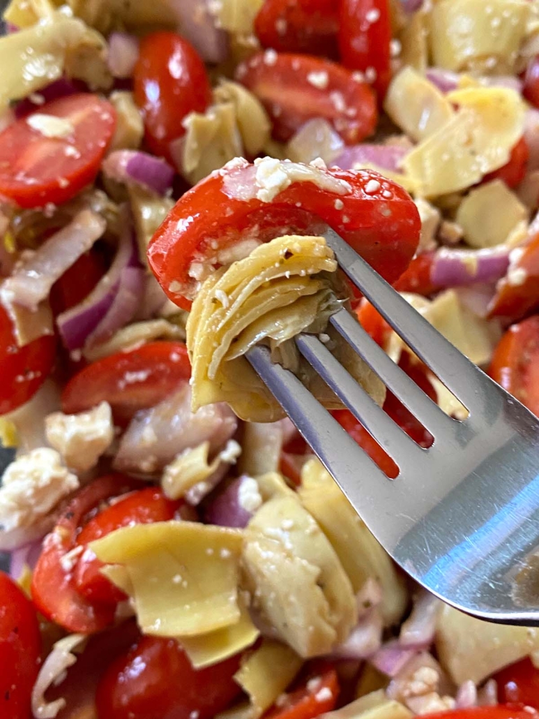 fork holding piece of artichoke salad