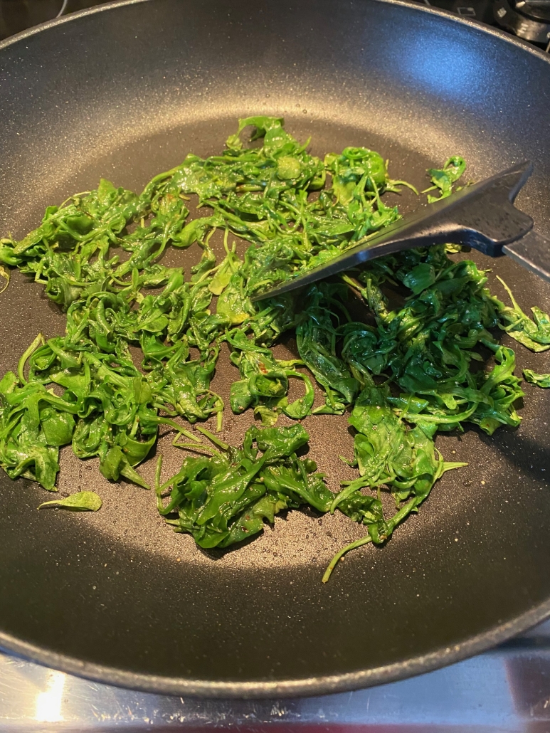 sautéed arugula cooking on the stovetop