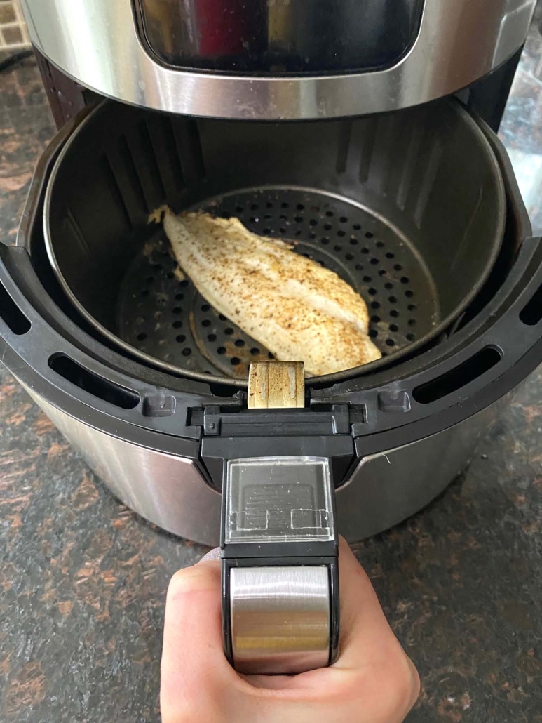 air fryer opened to show cooked swai fish