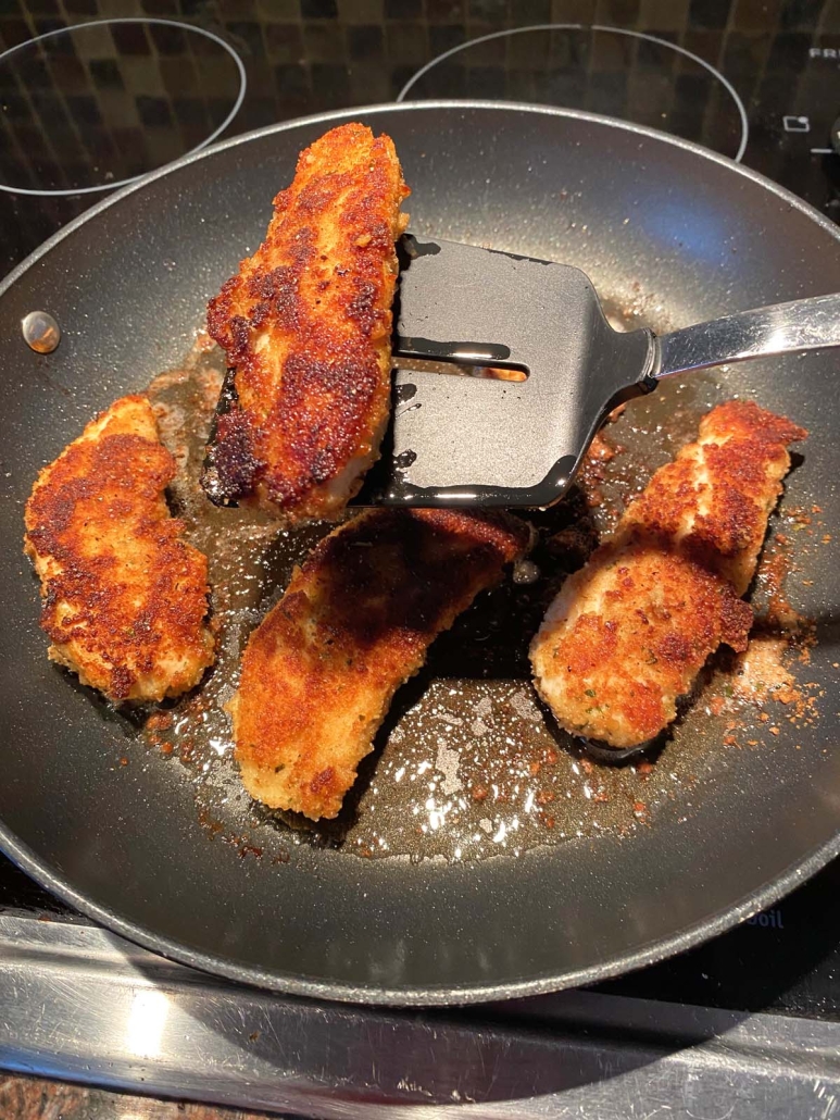 spatula flipping Pan Fried Breaded Chicken Tender