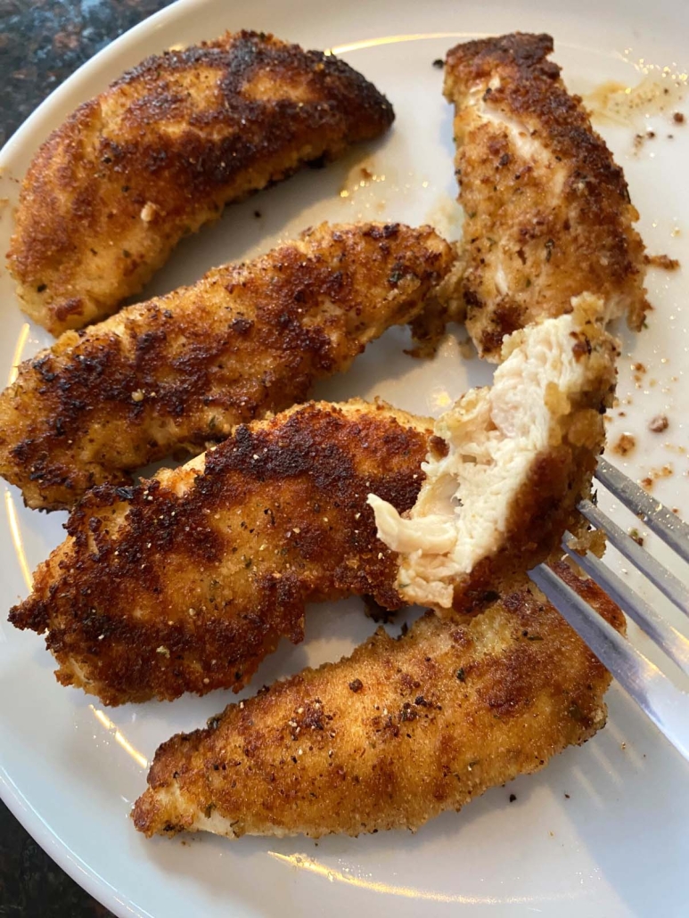 fork holding piece of flavorful Pan Fried Breaded Chicken Tender