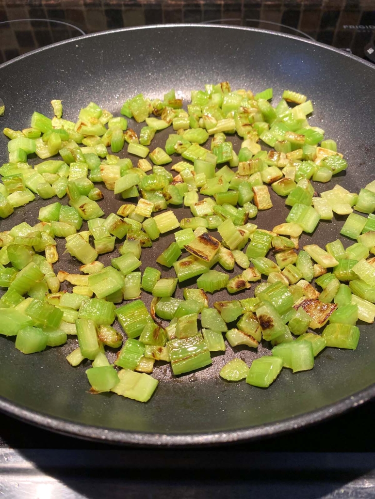 chopped celery cooking up in a pan