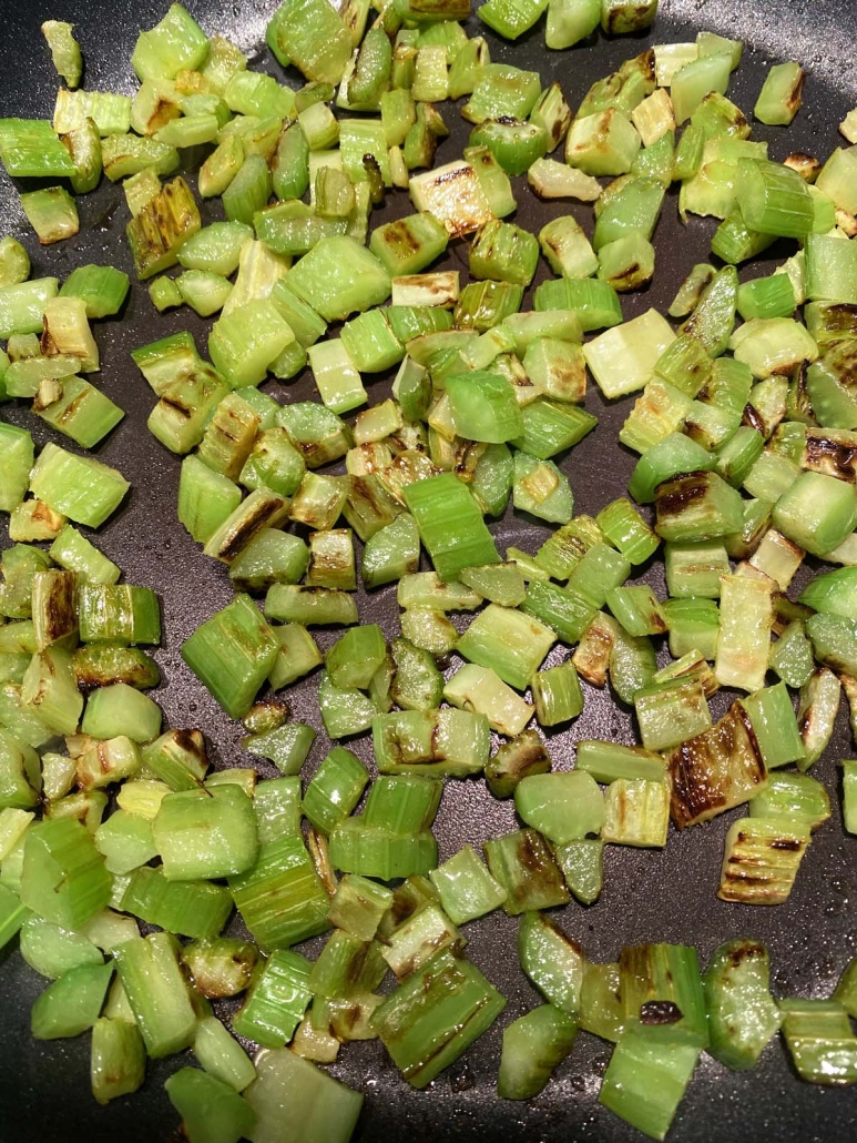 chopped celery sautéing in a skillet