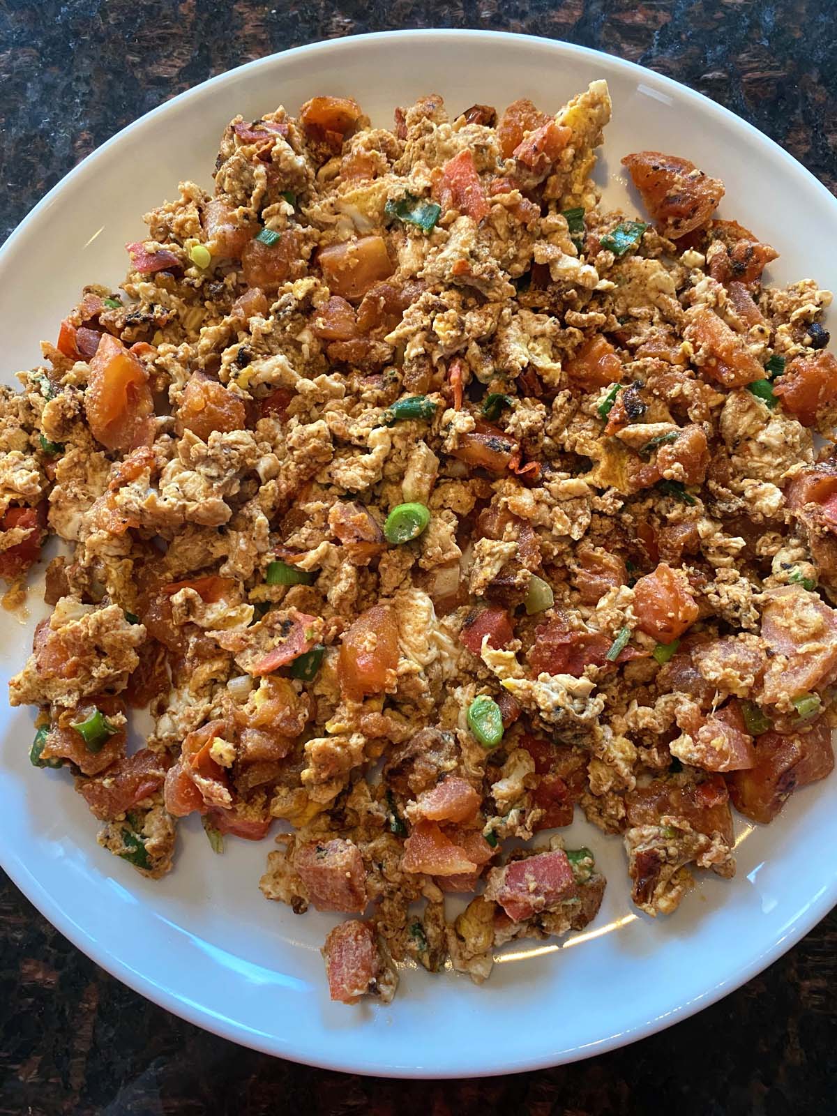 Chinese egg tomato stir fry on a white plate. 