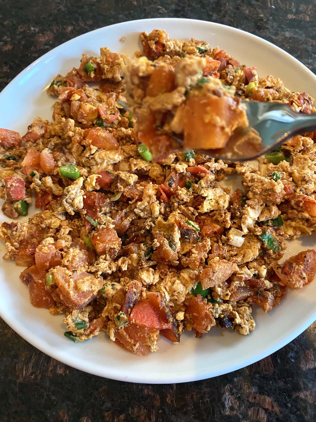 Chinese egg tomato stir fry on a white plate. 