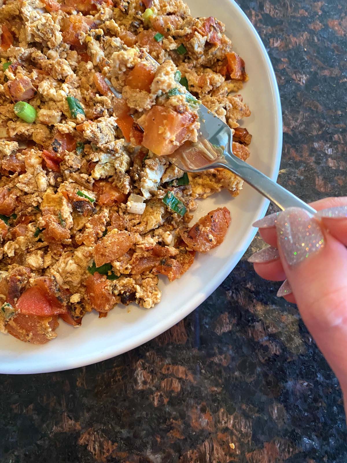 Chinese egg tomato stir fry on a white plate. 