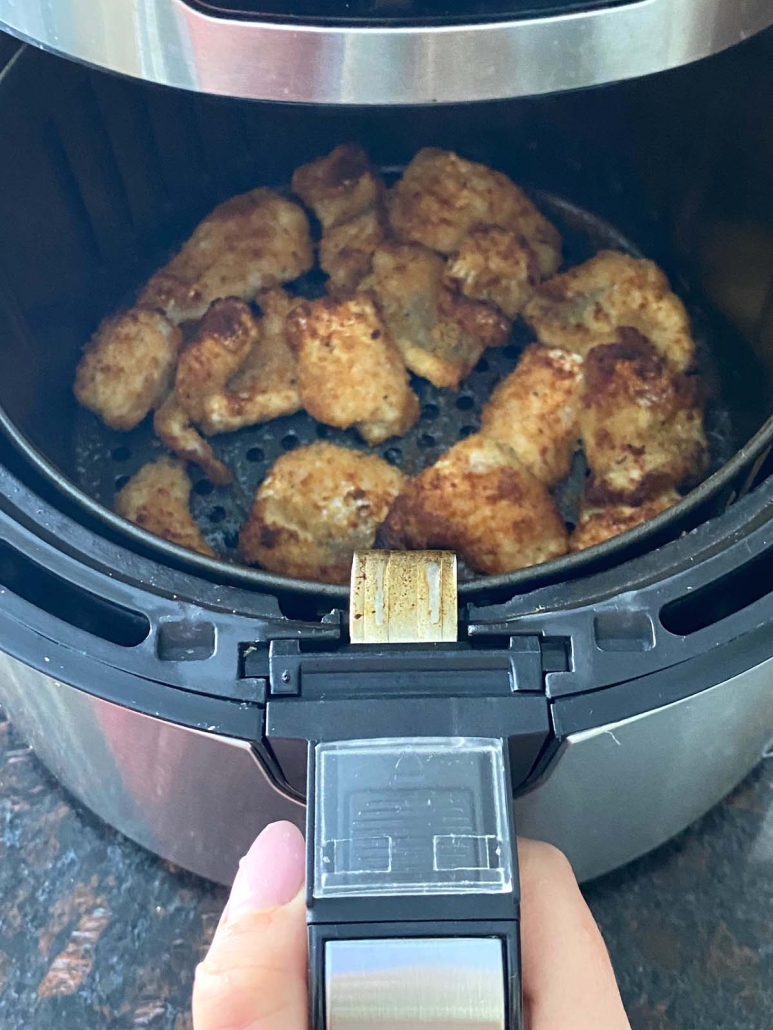 air fryer opened to show golden brown catfish nuggets