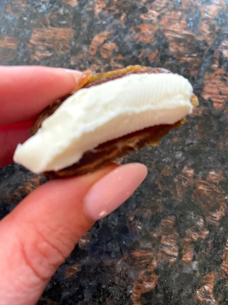hand holding Stuffed Date With Cream Cheese
