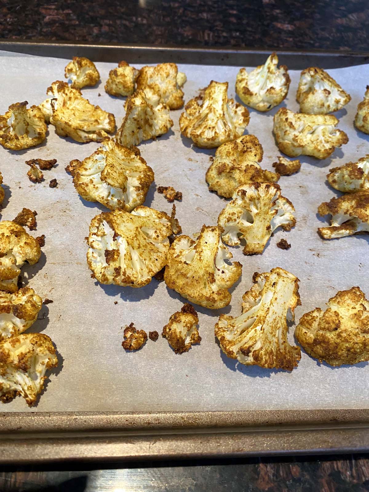 Roasted curried cauliflower on a baking sheet.