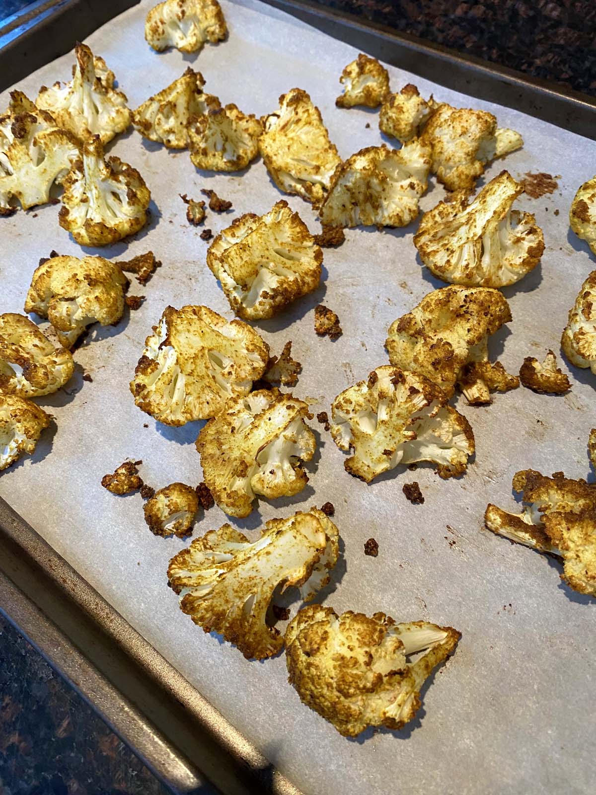 Roasted curried cauliflower on a baking sheet.