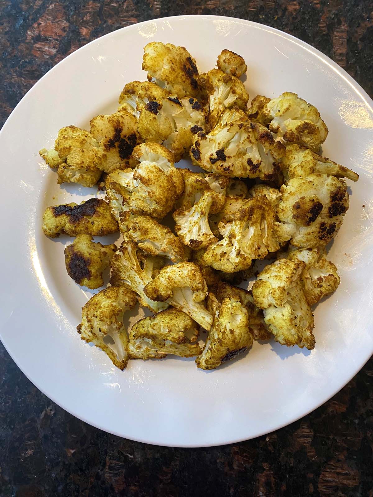 Roasted curried cauliflower on a white plate. 