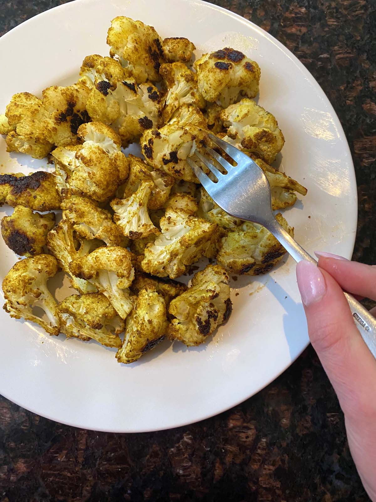 Roasted curried cauliflower on a white plate. 