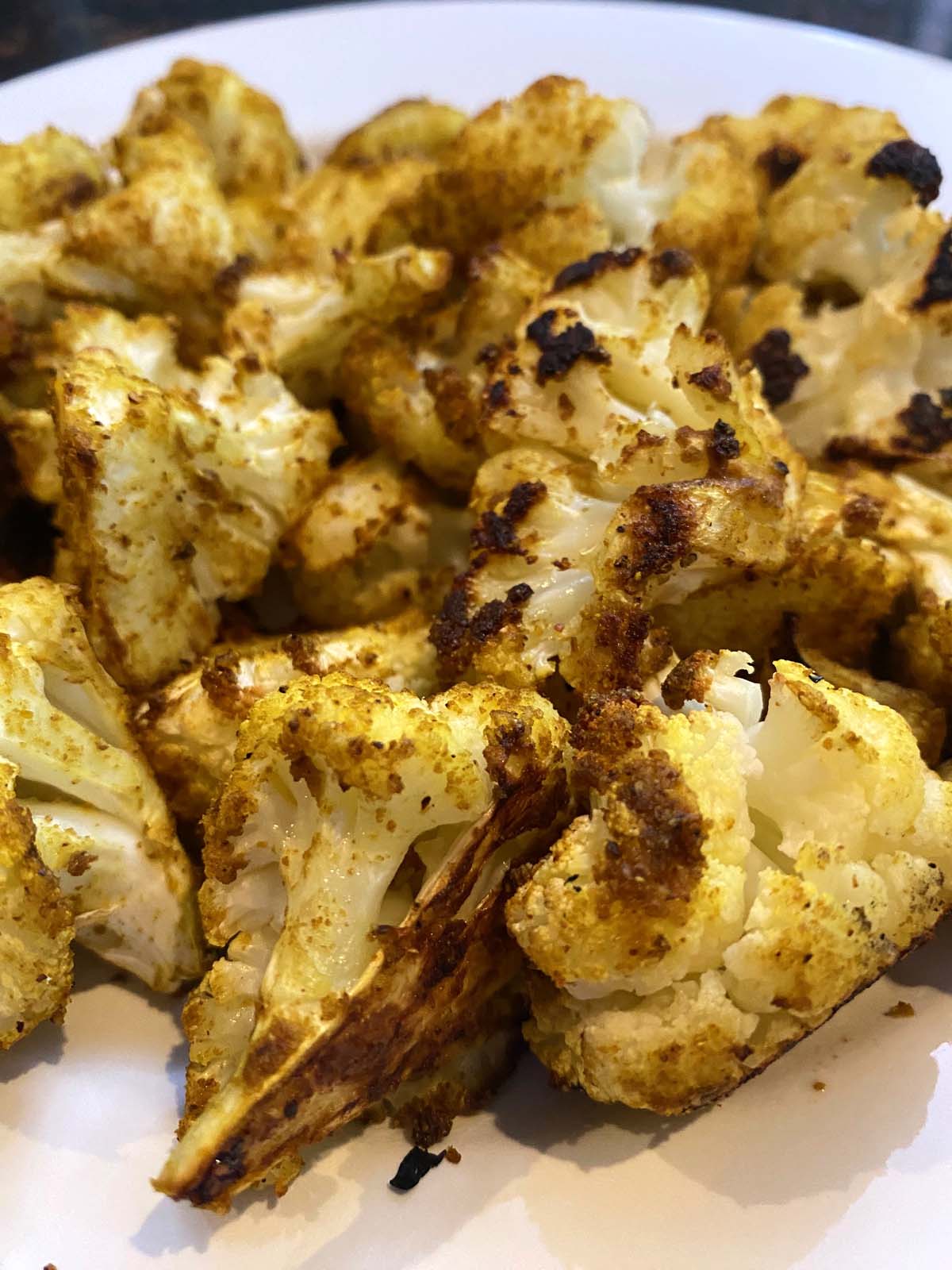 Roasted curried cauliflower on a white plate. 